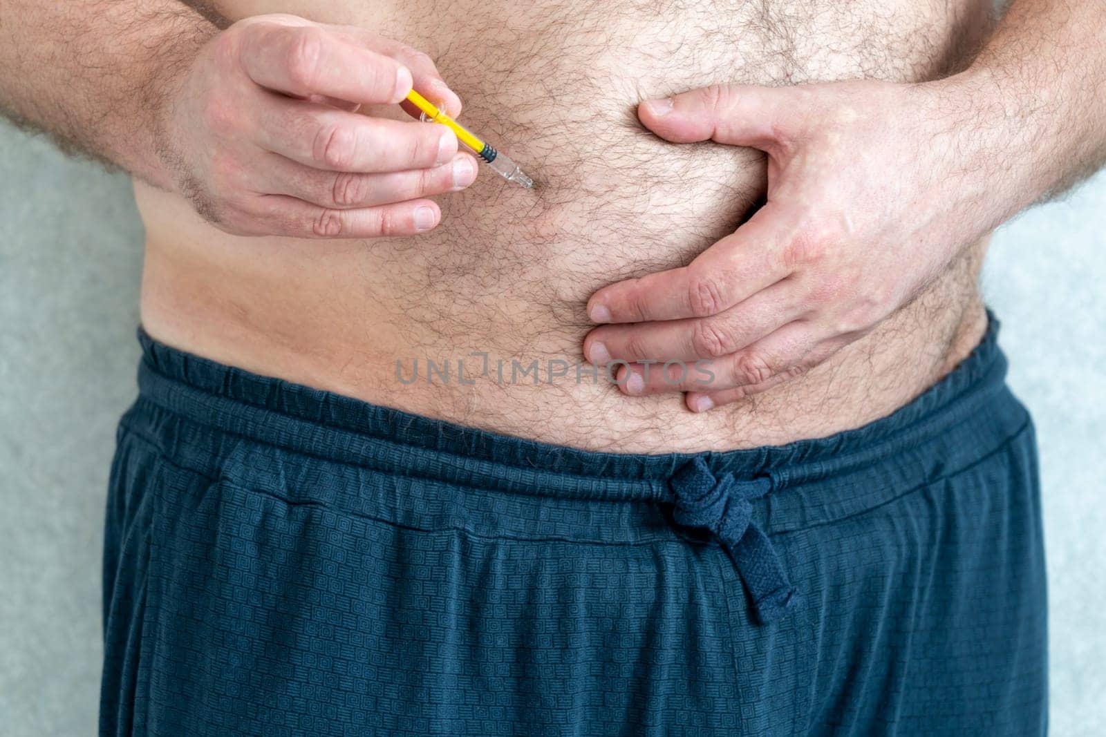 Blood thinners concept. Man making injection in his stomach