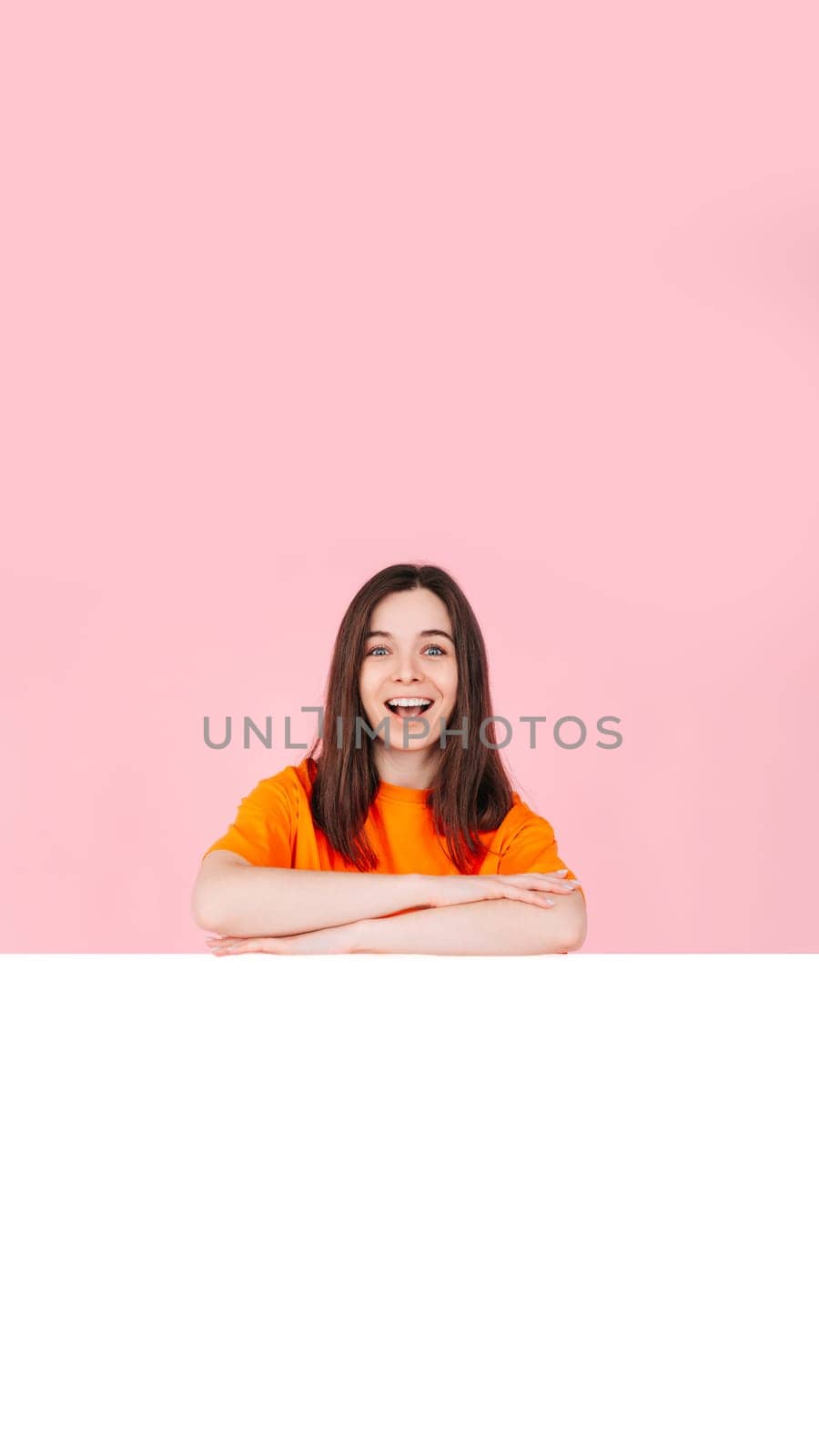 Young Woman in Shock and Excitement with Folded Arms, Standing in Front of a Large Empty Space Banner for Affordable Brand Offers. Perfect for Promotions, Sales, and Advertising Campaigns