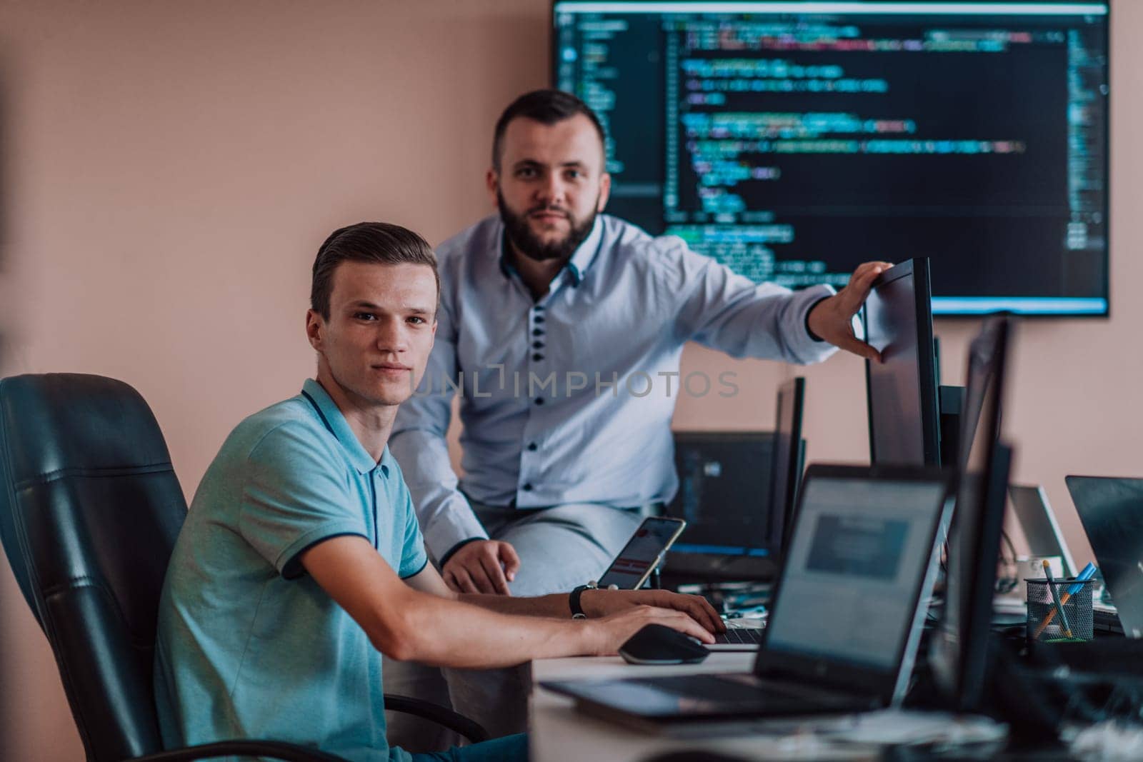 Programmers engrossed in deep collaboration, diligently working together to solve complex problems and develop innovative mobile applications with seamless functionality. by dotshock