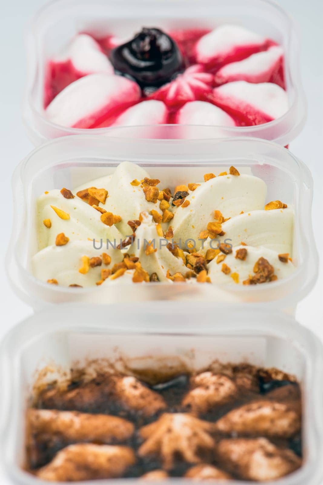 Set of ice cream of different varieties. Cherry ice cream, pistachio and cinnamon, in a cup isolated on a white background. The concept of a delicious and freezing treat for children and adults