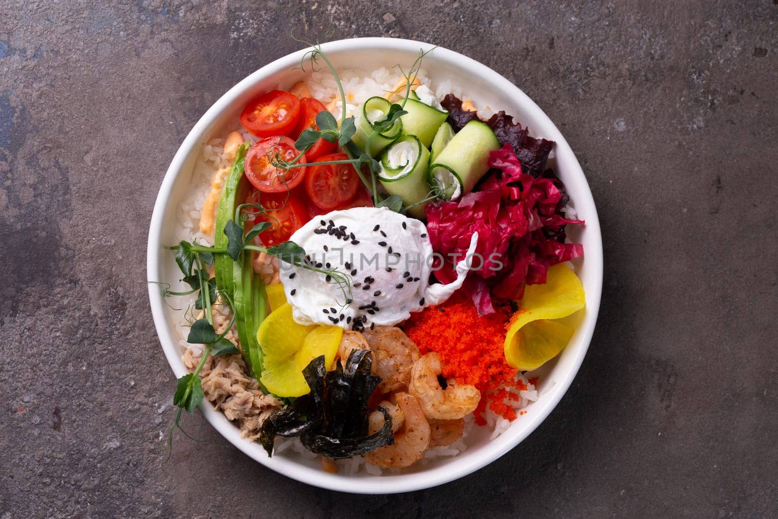 top view salad bowl with egg and shrimp, avocado, tobiko and other ingredients.