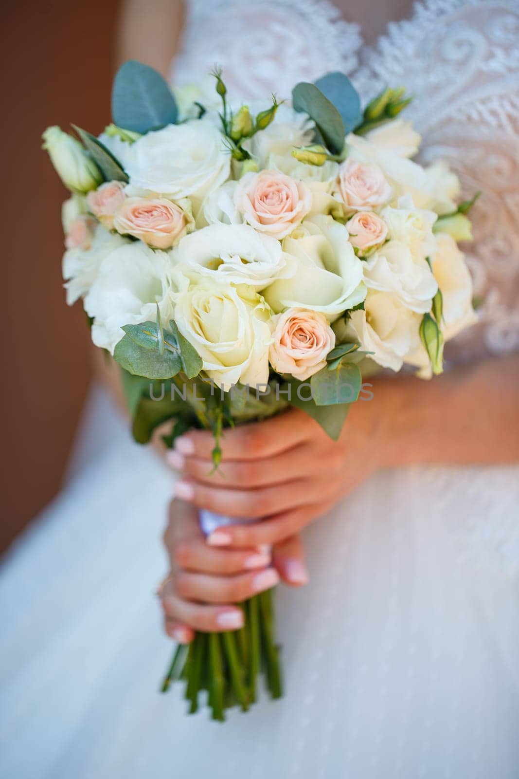 Hands of the bride close-up with a bouquet of fresh beautiful flowers. Attribute of the bride by Dmitrytph