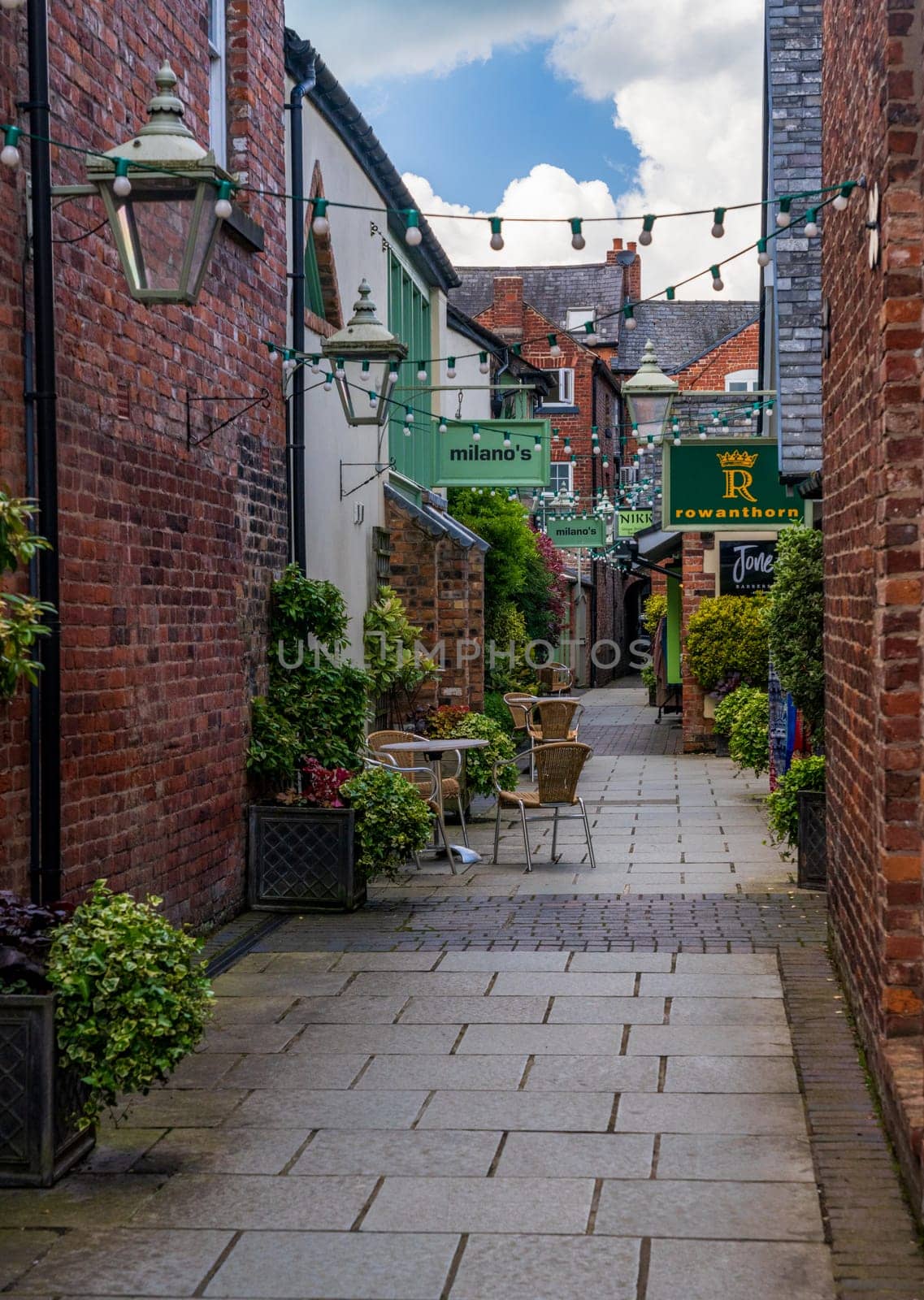 Oswestry, Shropshire - 12 May 2023: Shops and cafes along Old Chapel Court in market town of Oswestry