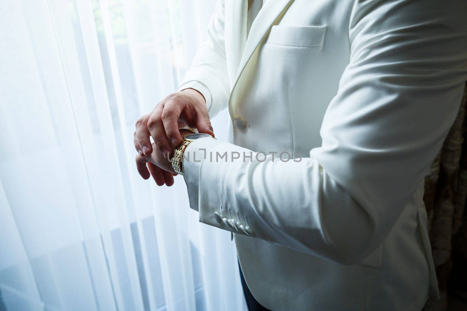 man puts a watch on his hand