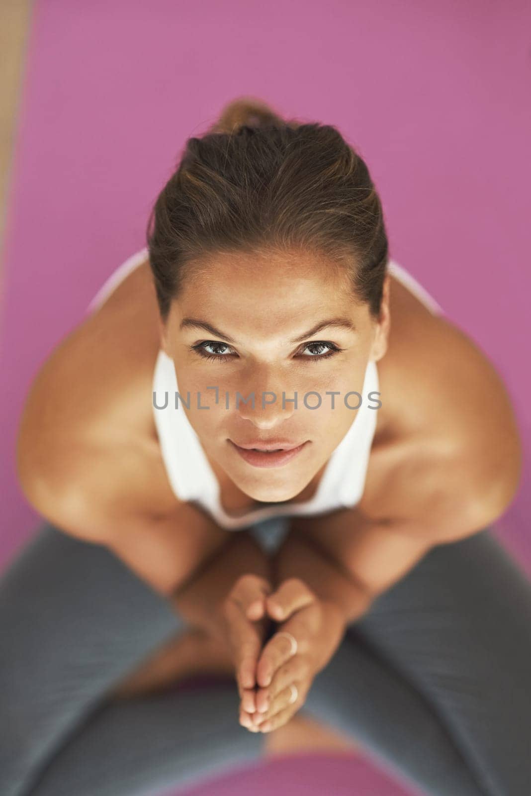 Yoga is an all-natural detox. High angle shot of a young woman practicing yoga at home. by YuriArcurs