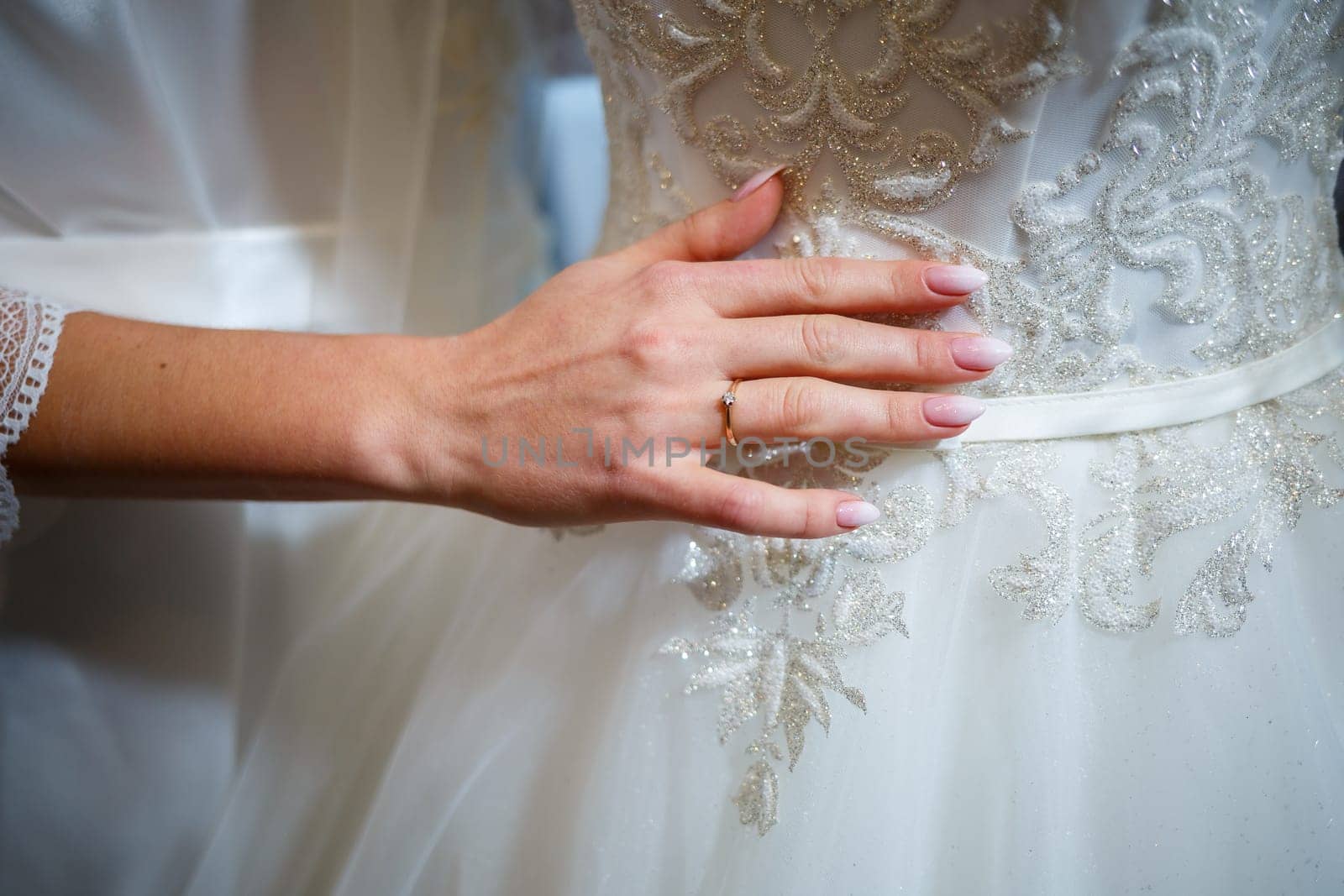 the bride holds in her hands a beautiful wedding dress