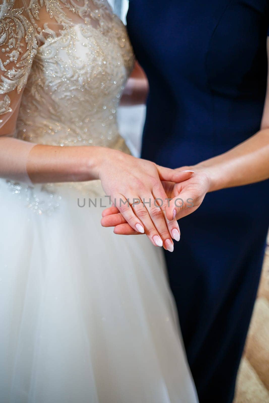 gold wedding rings in the hands of the newlyweds by Dmitrytph