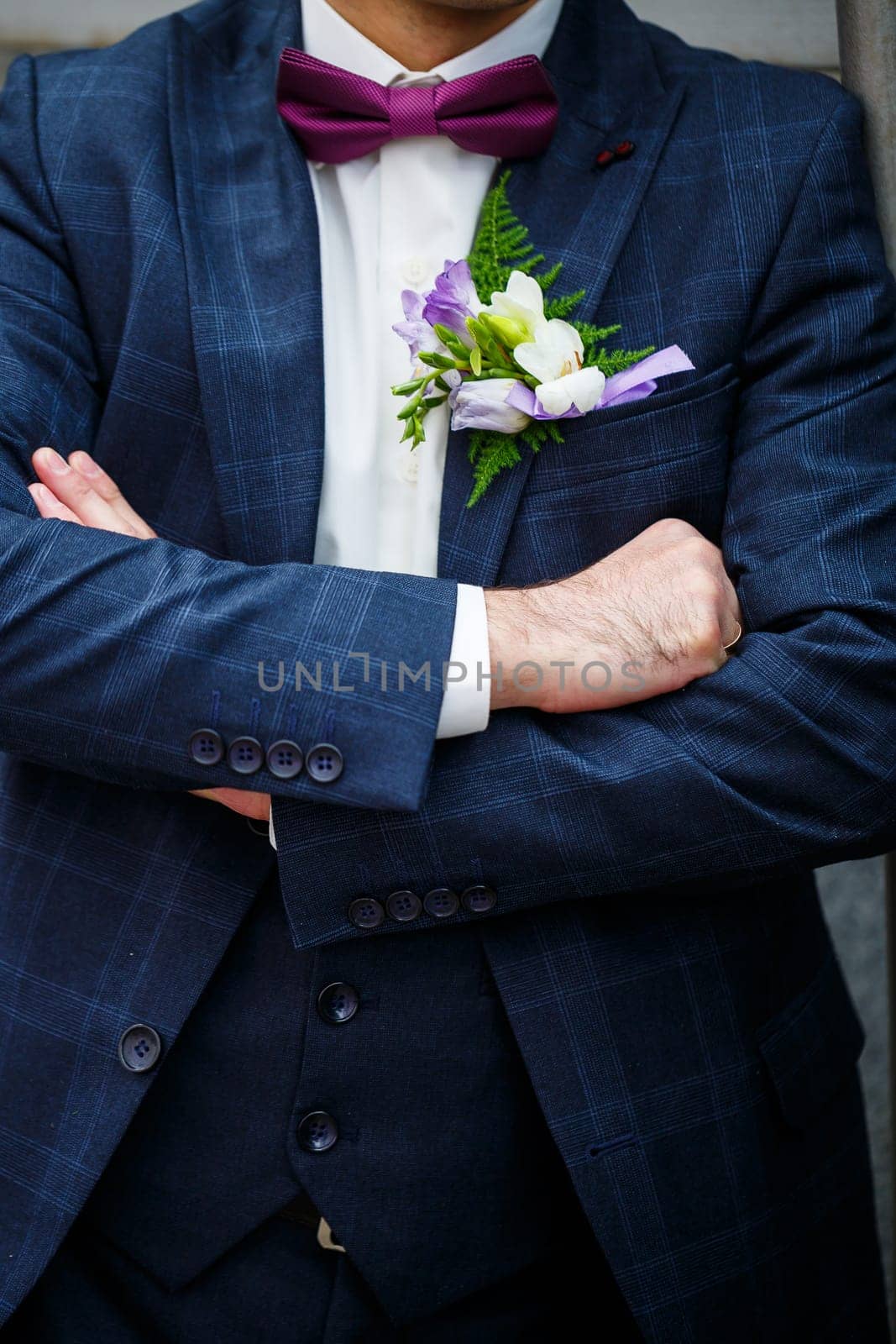 Man puts on a wedding suit and accessories on the wedding day. by Dmitrytph