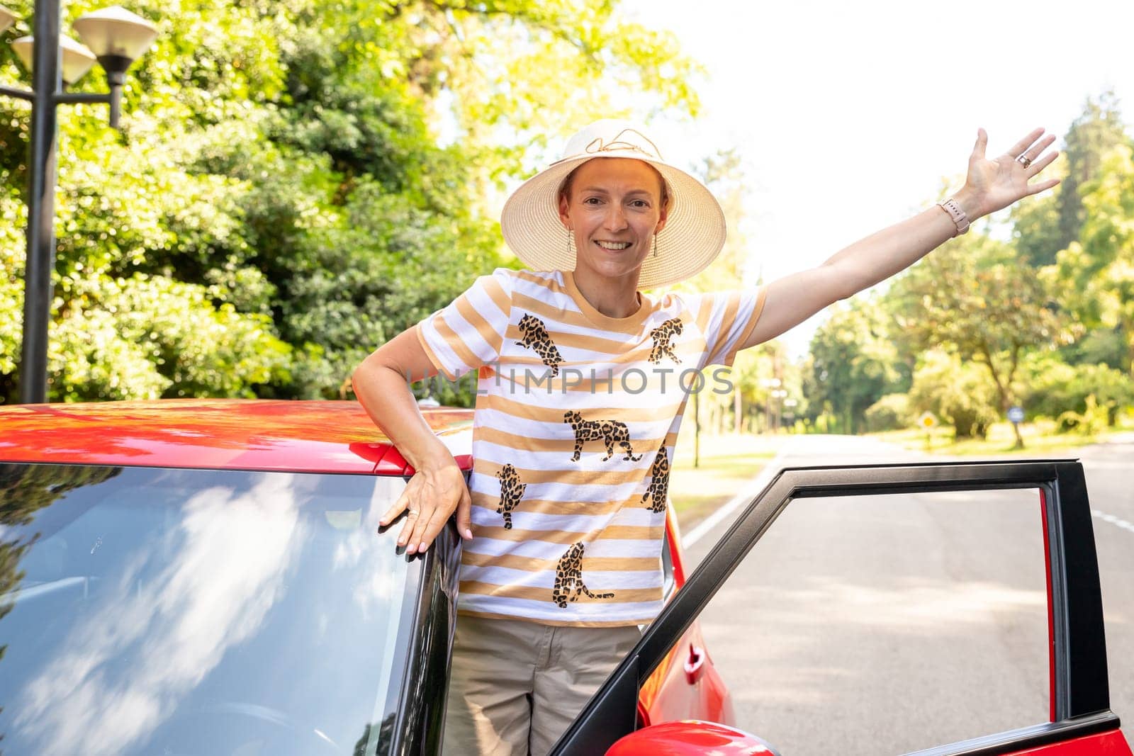 Photo of positive cheerful girl funky driver rider enjoy drive ride car under pop star hits playlist music try dance raise hands in city center