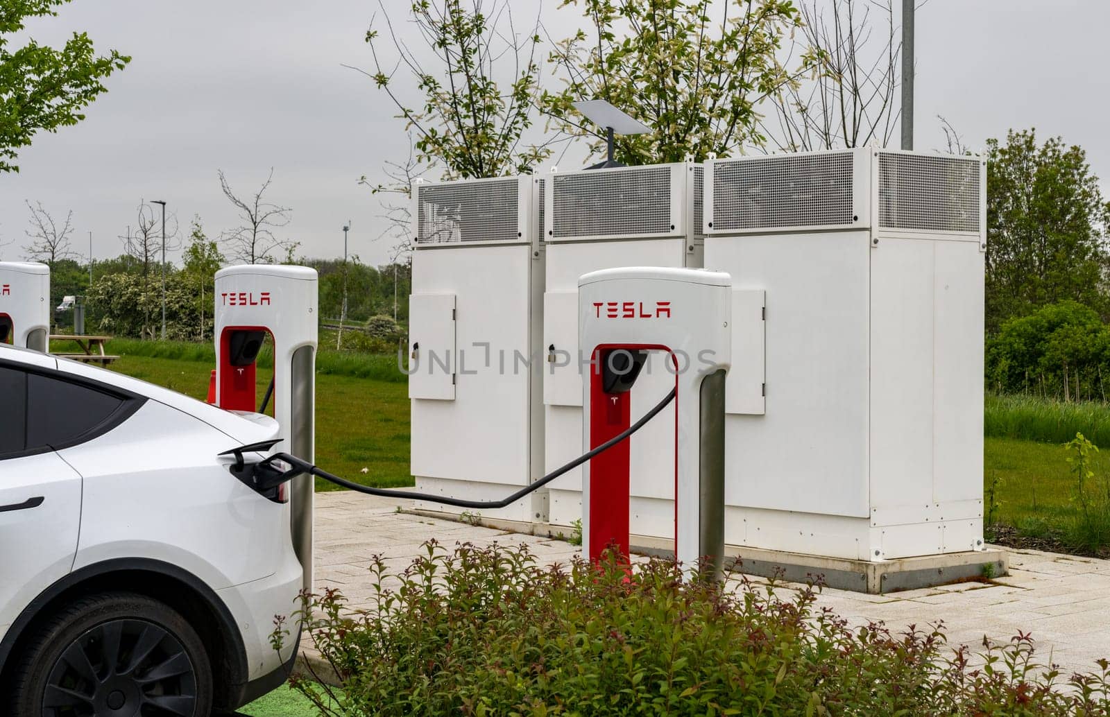 Tesla electric vehicle charging station on motorway in UK by steheap