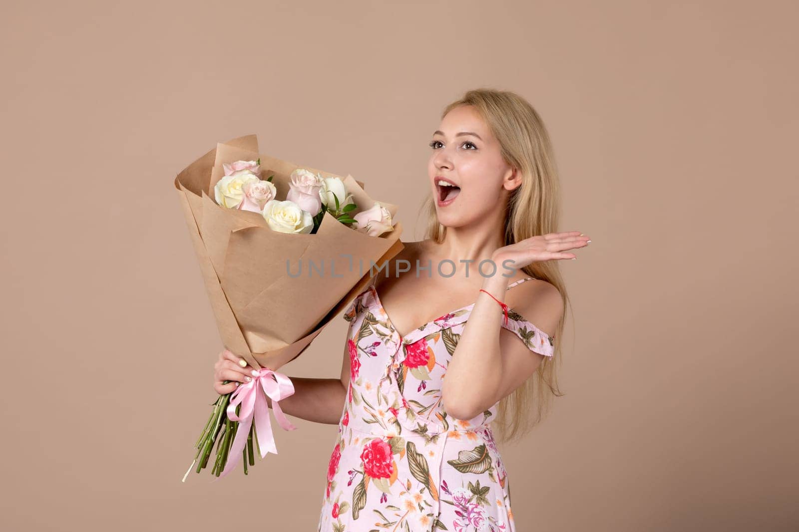 front view young female holding bouquet of beautiful roses on brown background feminine sensual woman horizontal march gifts marriage equality by Kamran