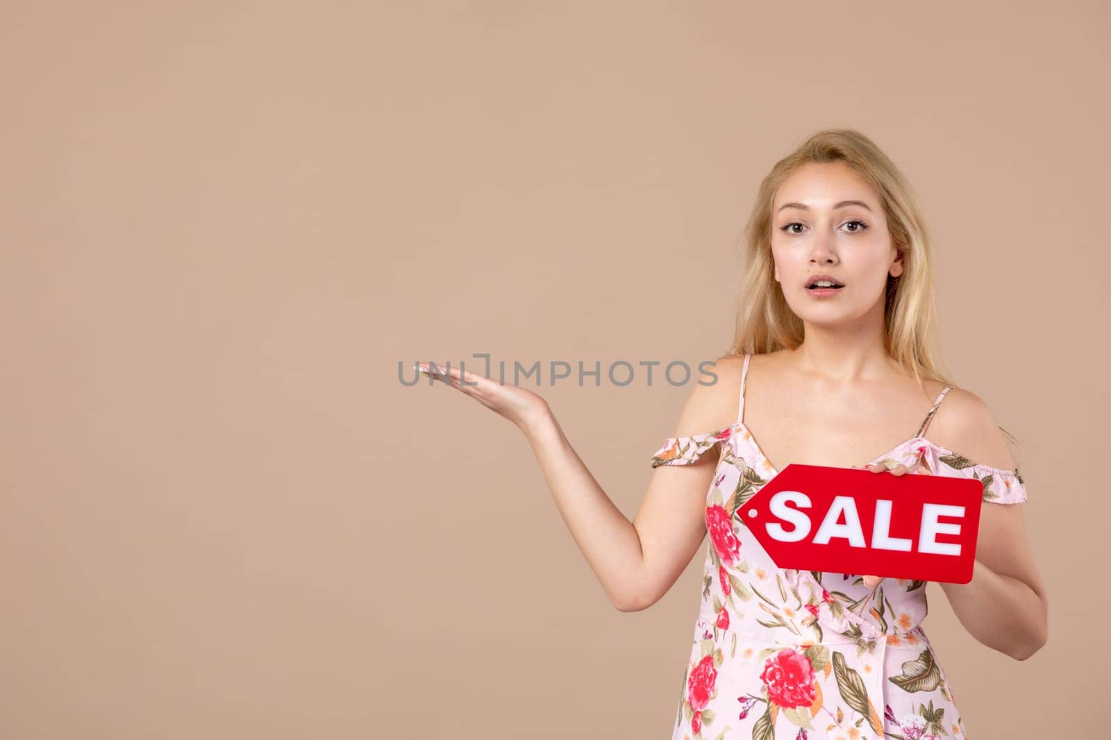 front view young female holding red sale nameplate on brown background money march horizontal sensual shopping woman equality feminine by Kamran