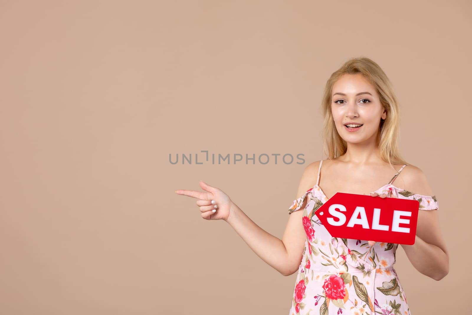 front view young female holding red sale nameplate on brown background money march sensual shopping woman equality feminine