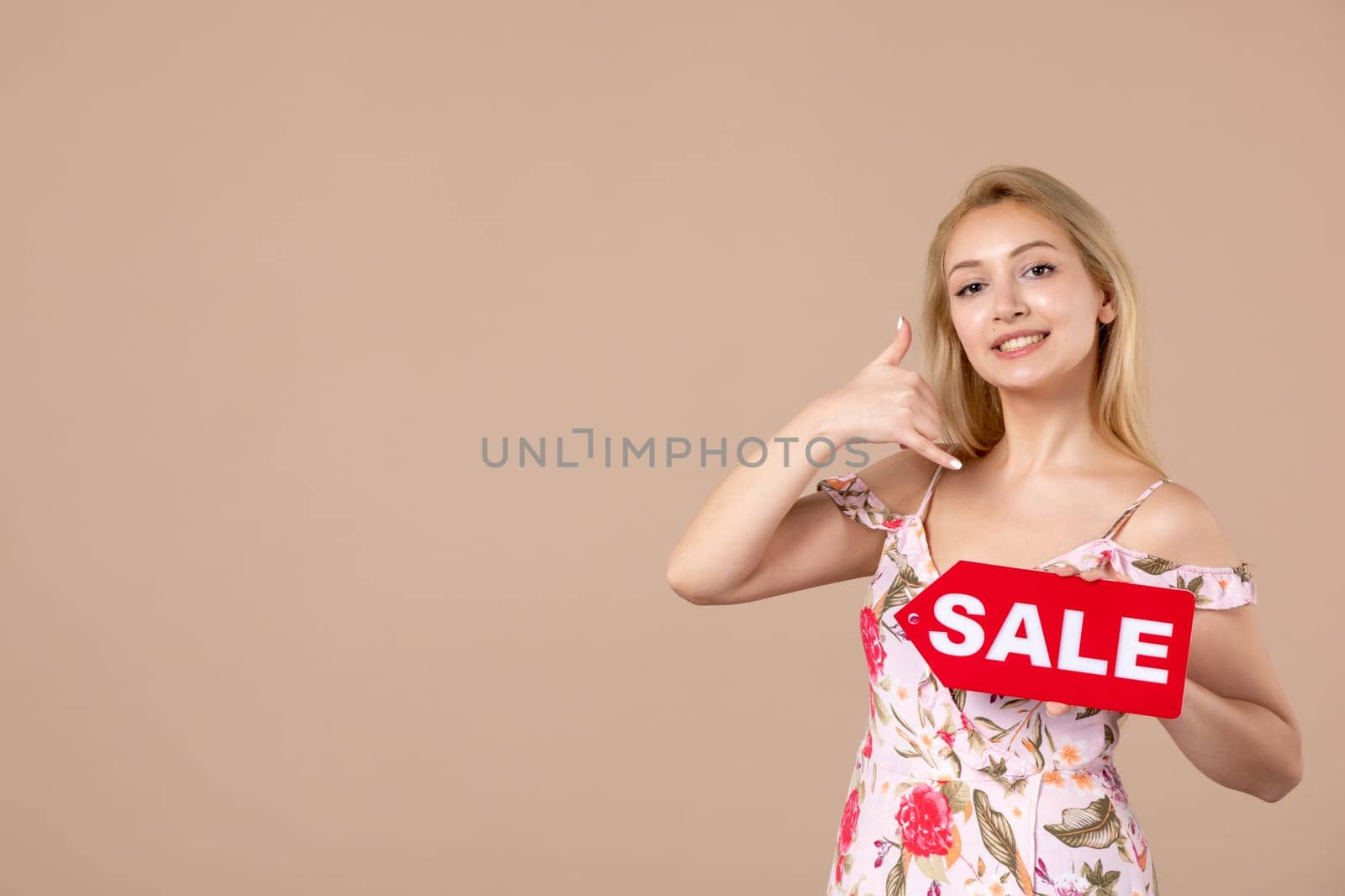 front view young female holding red sale nameplate on brown background woman money march sensual shopping equality feminine