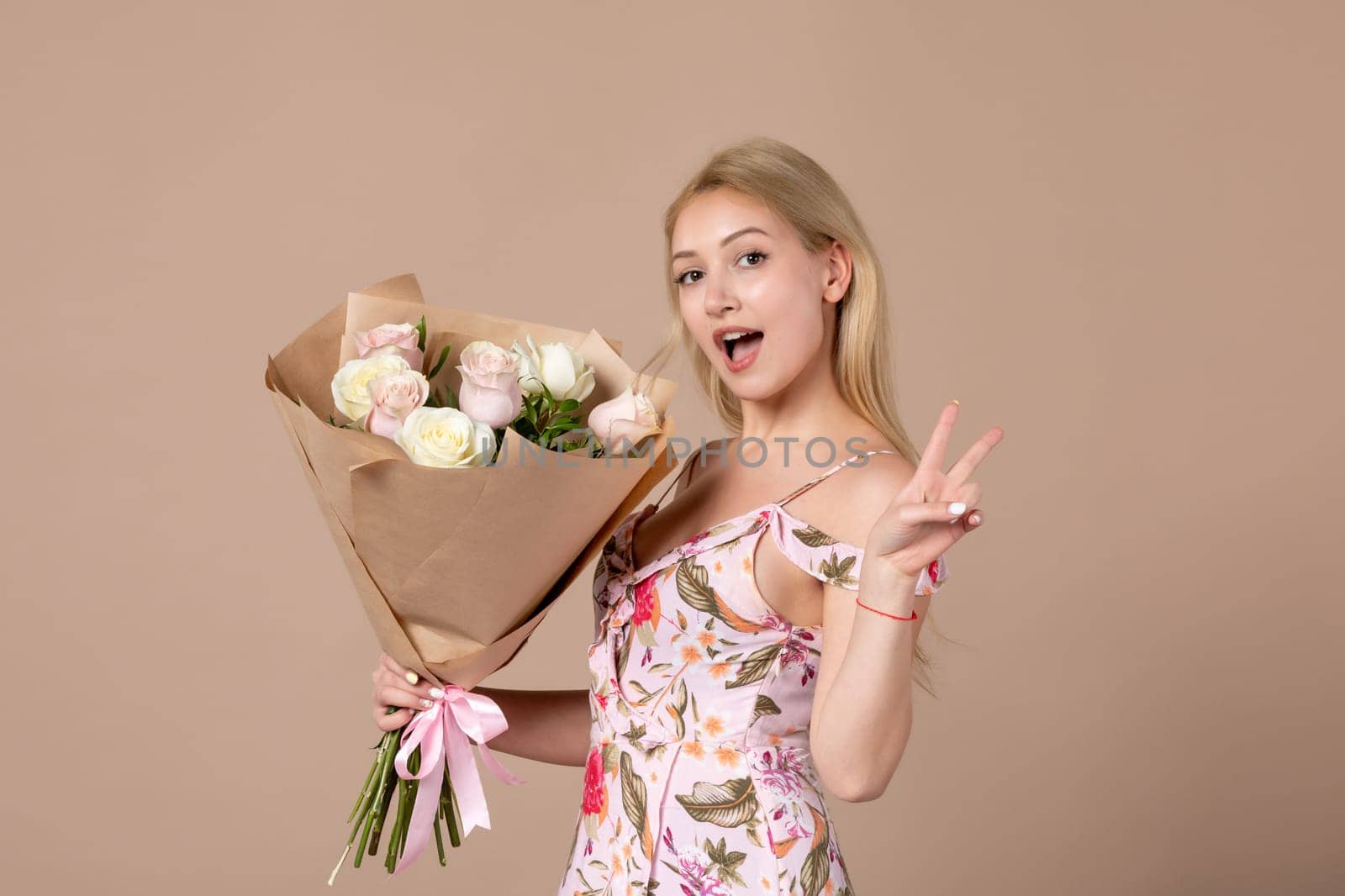 front view young female posing with bouquet of beautiful roses on brown background feminine sensual woman horizontal march gifts marriage equality