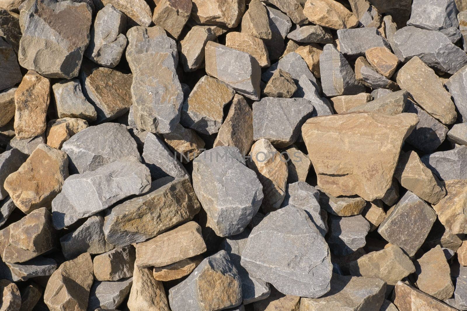 Gravel texture. Pebble stone background. Light grey closeup small rocks. Top view of ground gravel road
