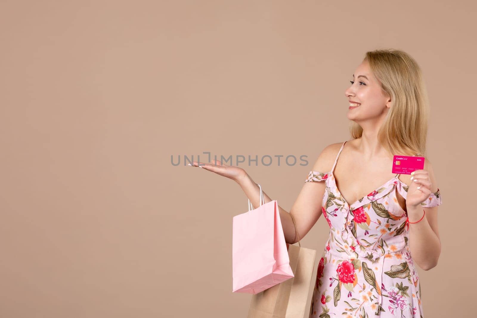 front view young female with present packages and bank card on brown background feminine sensual money march woman shopping equality marriage