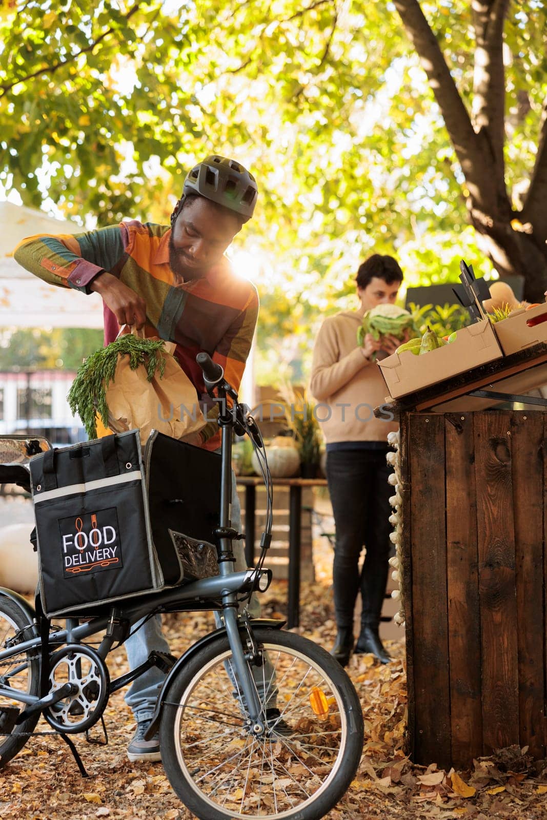 Deliveryman with thermal backpack picking up fresh produce order by DCStudio