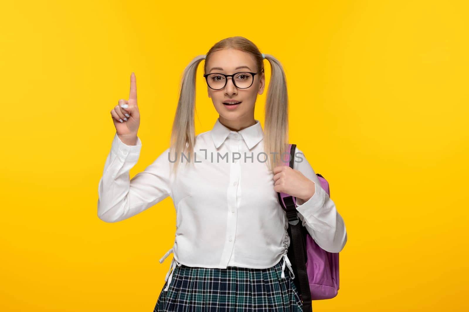 world book day blonde young girl with ponytails on yellow background
