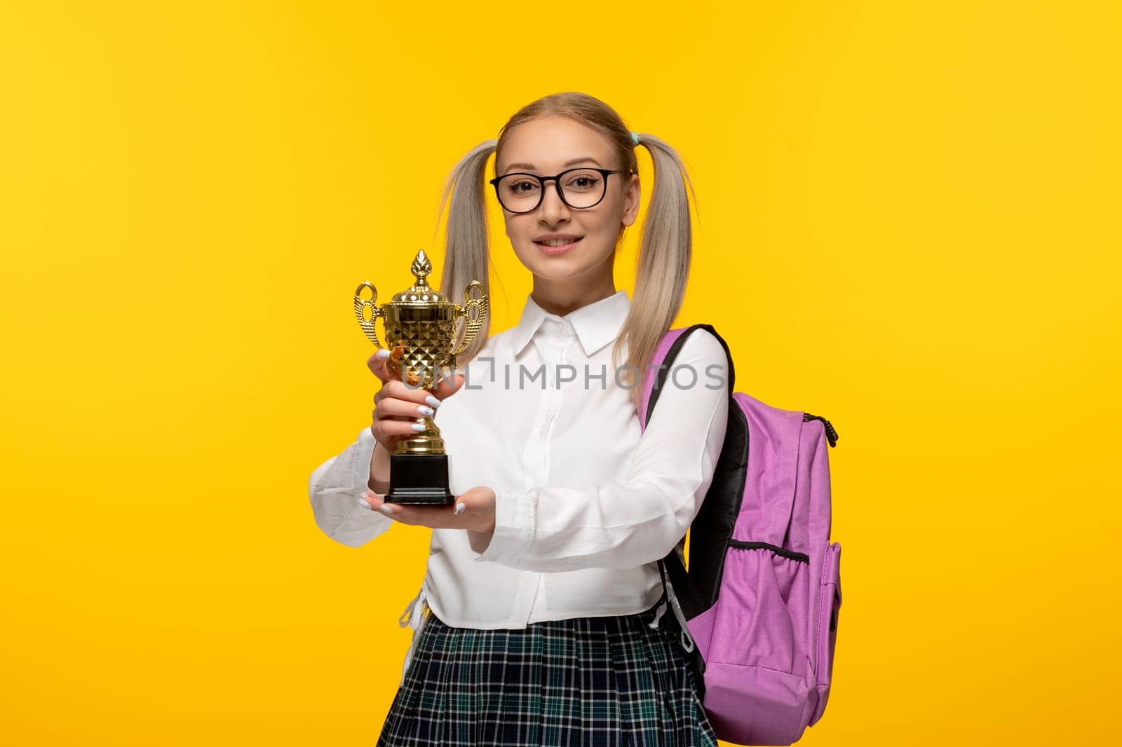 world book day happy smiling school girl holding a trophy and wearing glasses