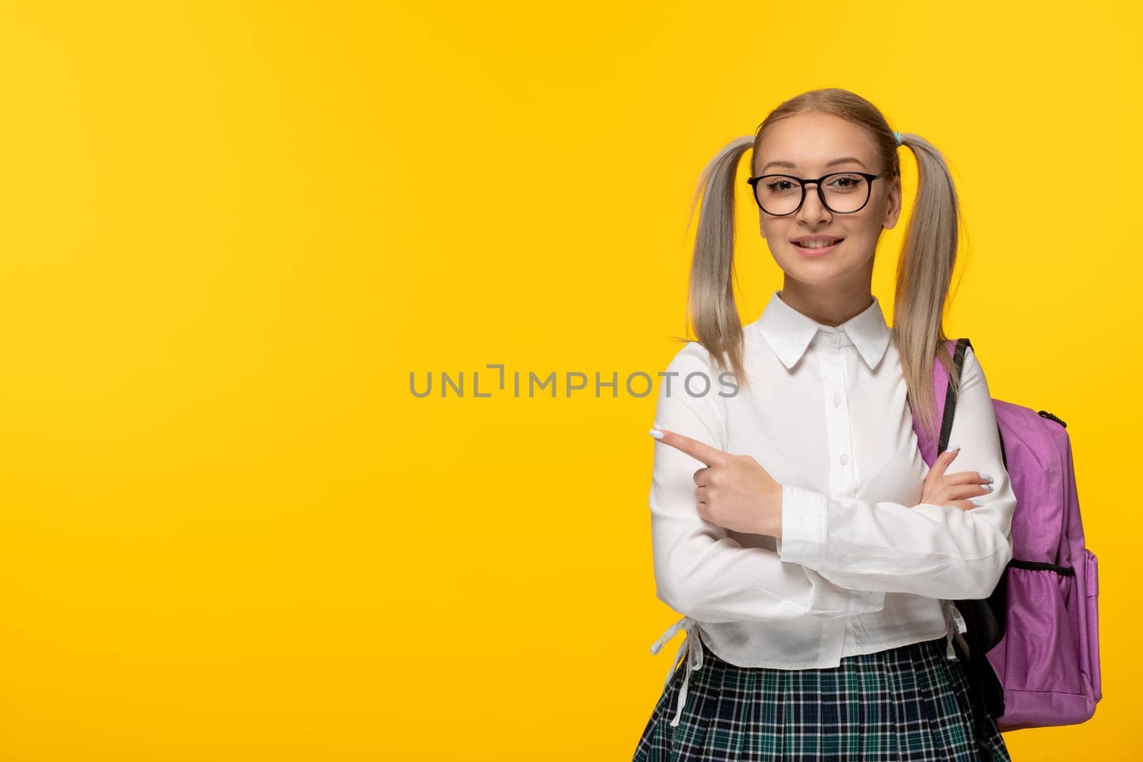 world book day school girl with crossed hands on yellow background with backpack by Kamran