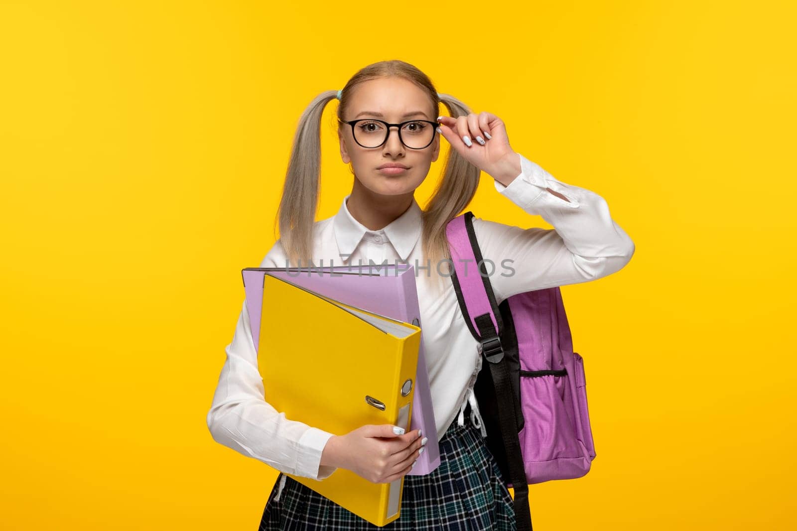 world book day blonde girl with ponytails wearing backpack and holding folders by Kamran