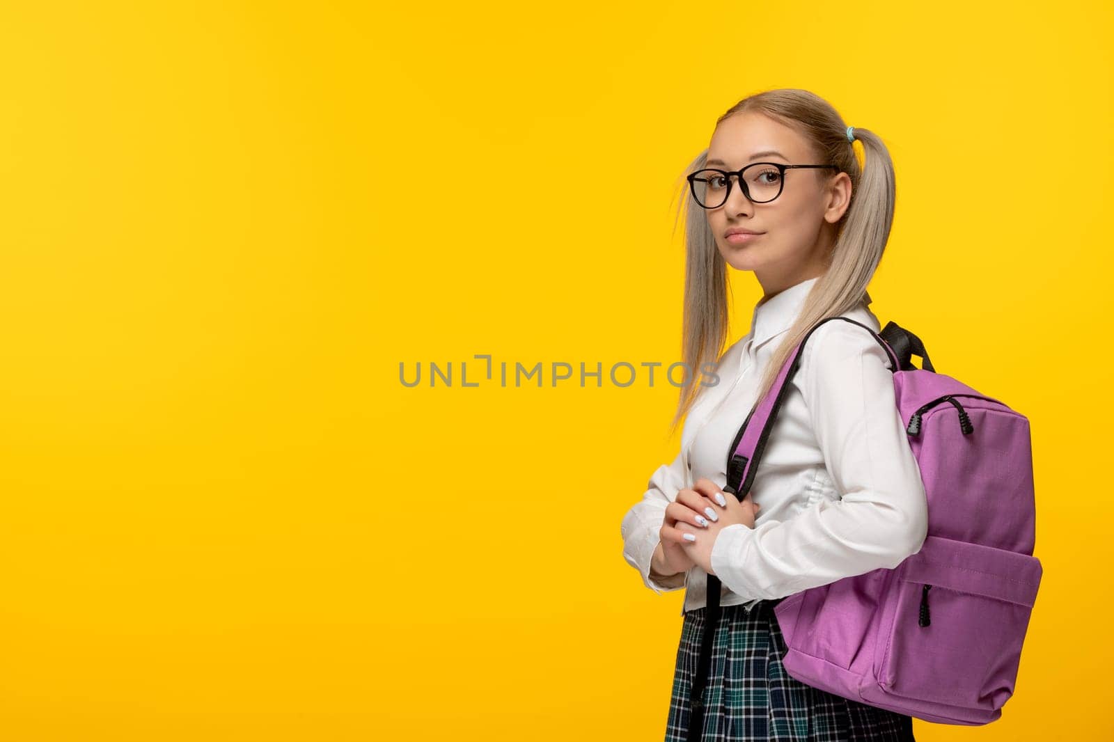 world book day blonde student with pony tails and glasses on yellow background