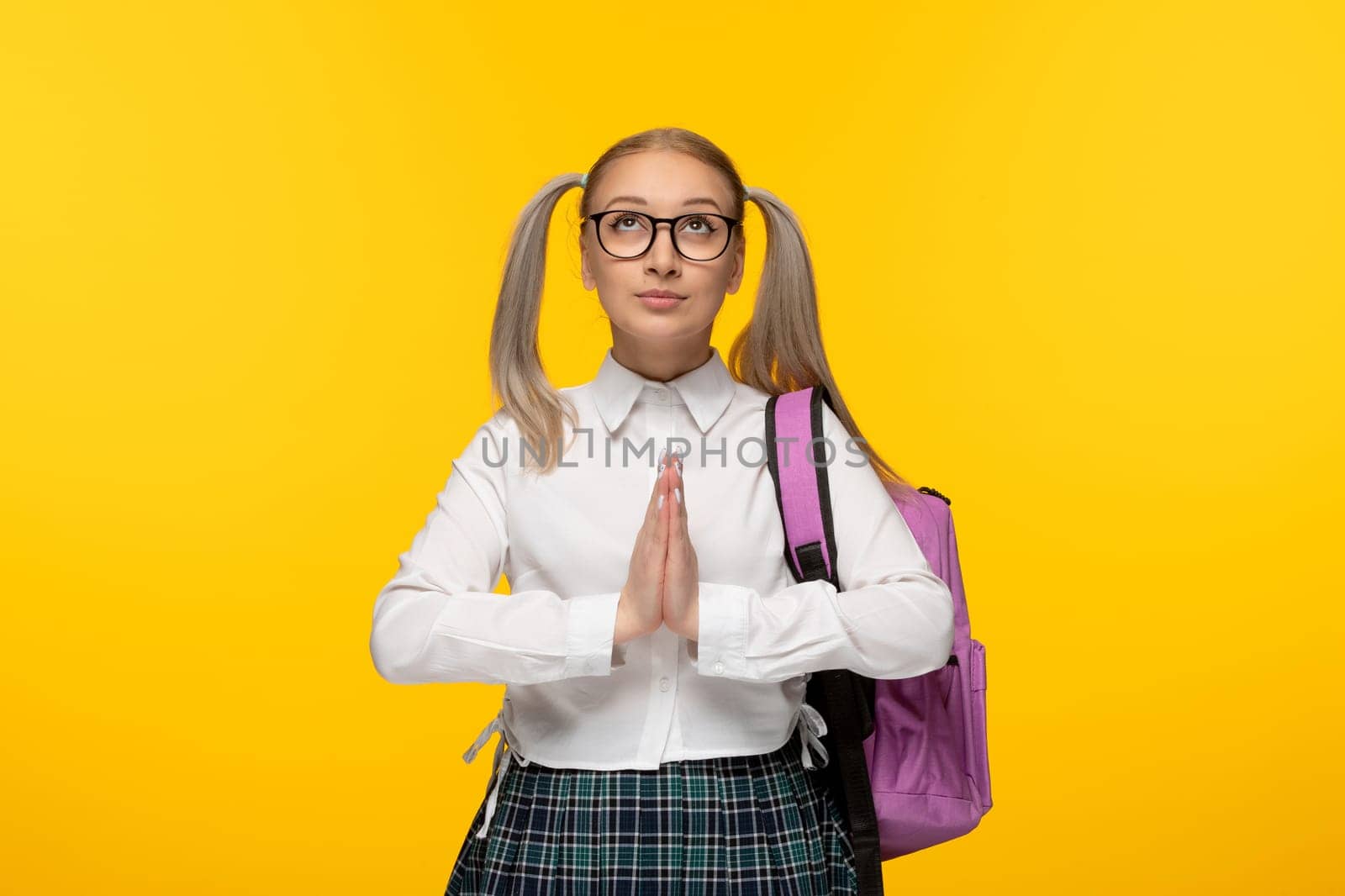 world book day blonde young girl praying hands together on yellow background