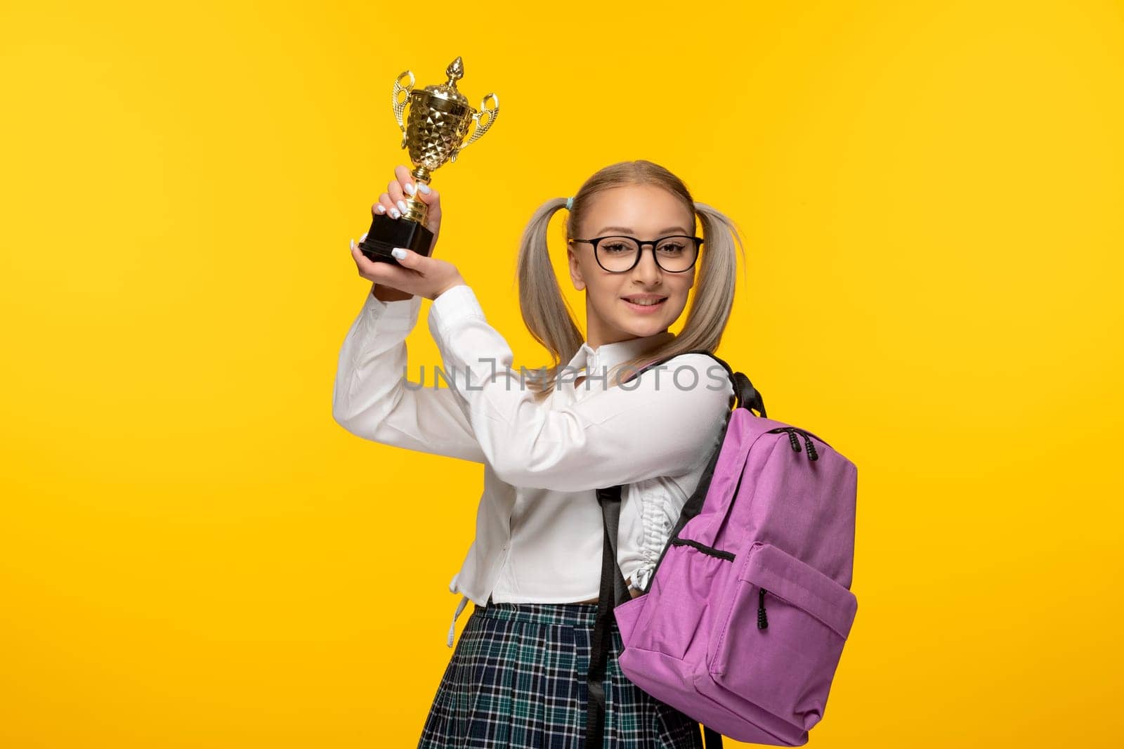 world book day excited blonde schoolgirl on yellow background holding a price by Kamran