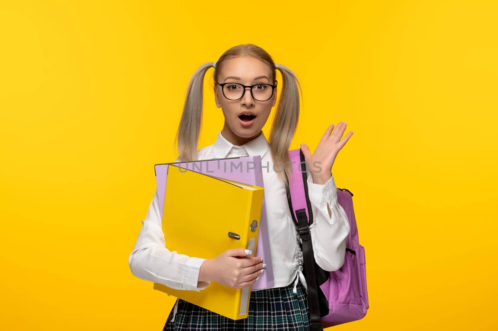 world book day excited blonde schoolgirl with waving hands wearing glasses