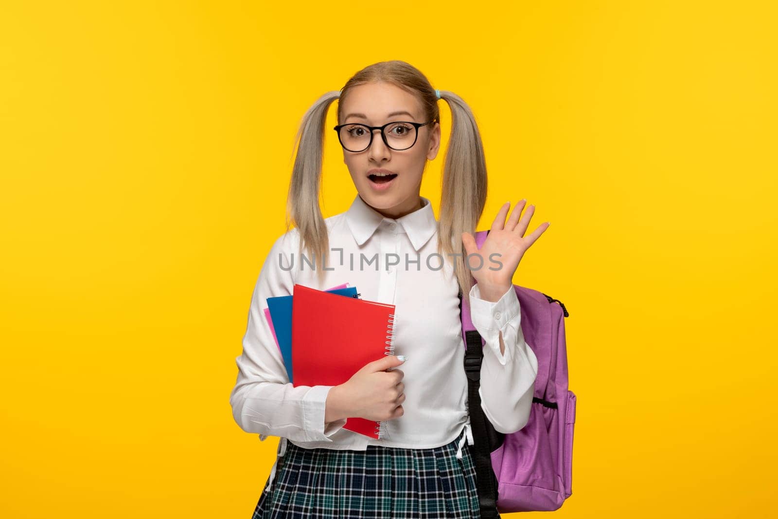 world book day excited school girl waving hands and keeping pile of notebooks by Kamran