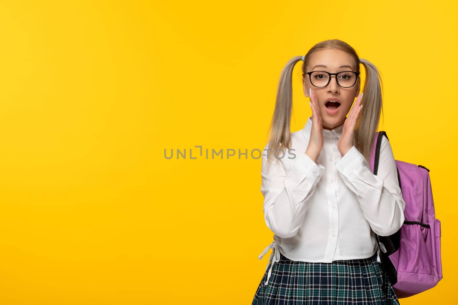 world book day excited school girl with hands on face and pink back pack