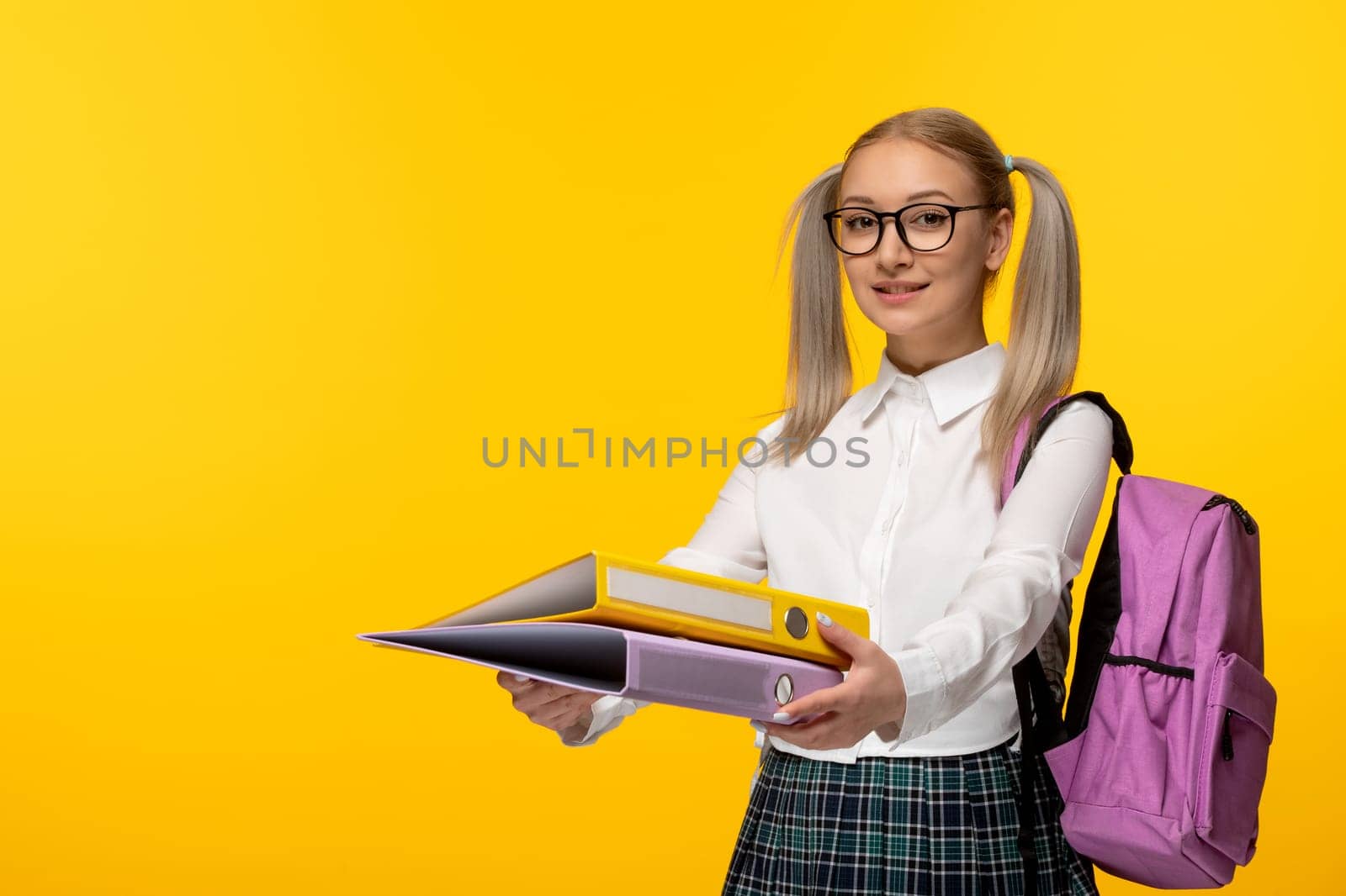 world book day happy blonde girl with pony tails in glasses giving folders by Kamran