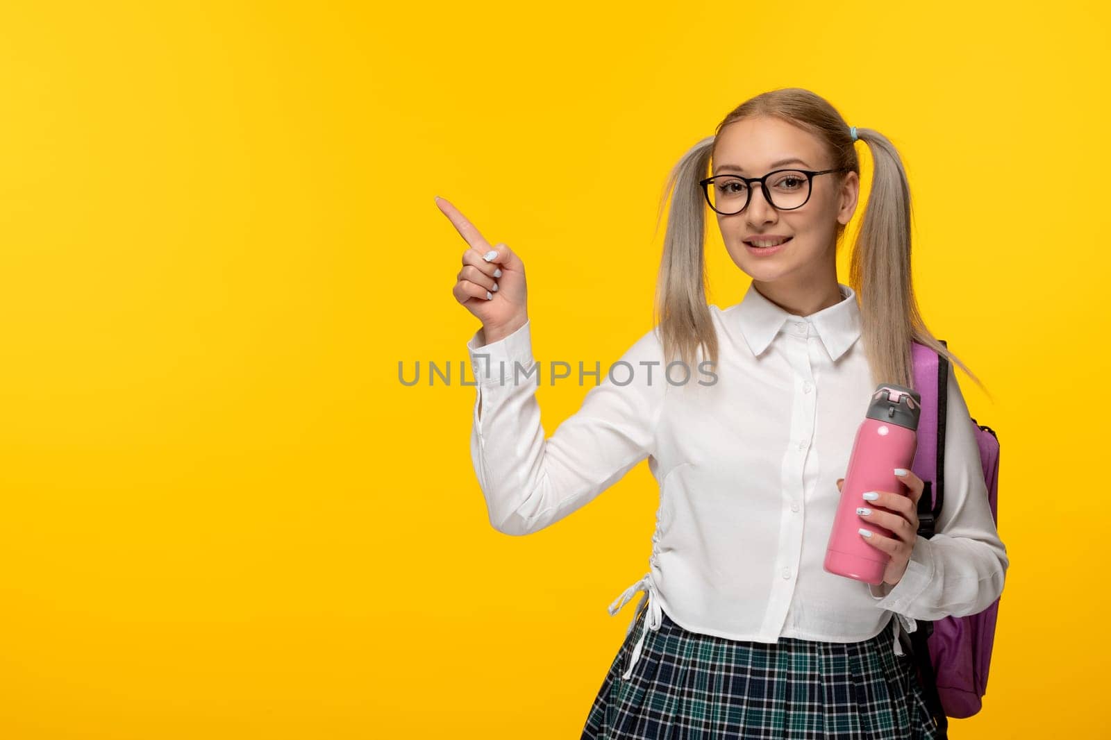 world book day happy blonde schoolgirl in cute uniform with pink flask