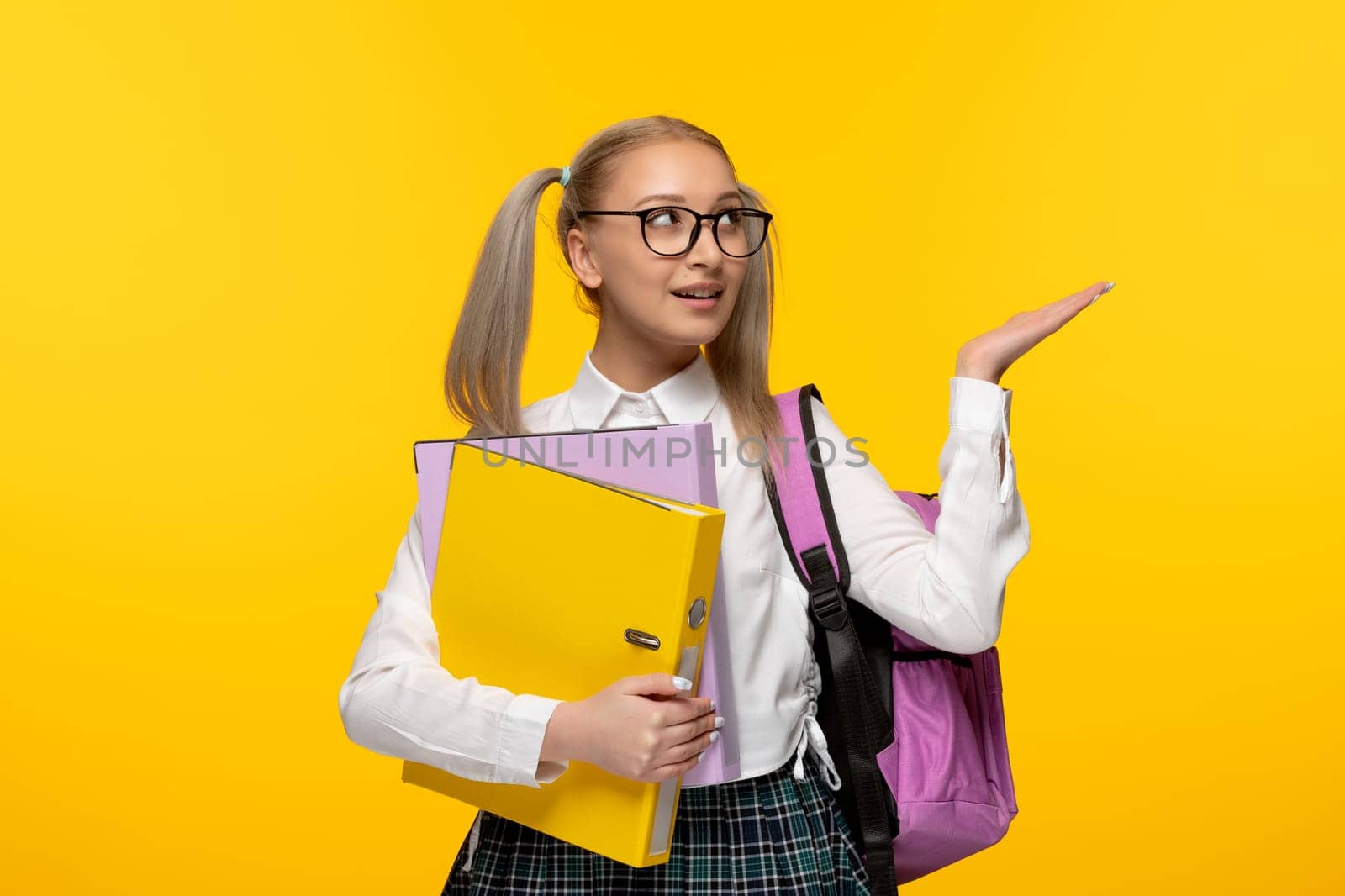 world book day happy girl with ponytails holding folders and wearing glasses