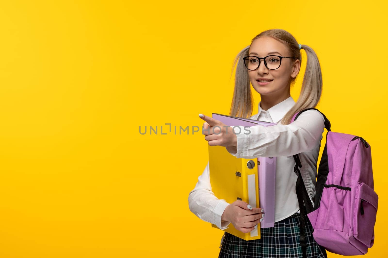 world book day school girl with glasses pointing left with pink backpack