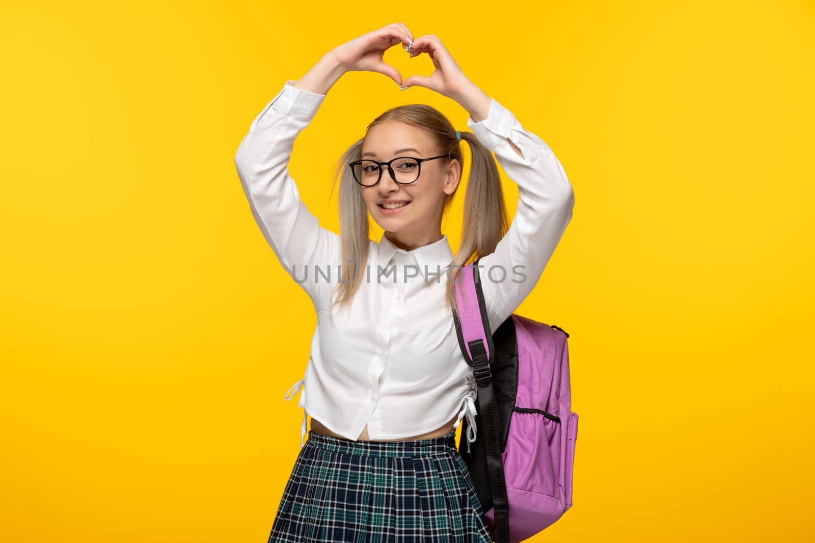 world book day schoolgirl cute showing heart with hands with pink backpack by Kamran