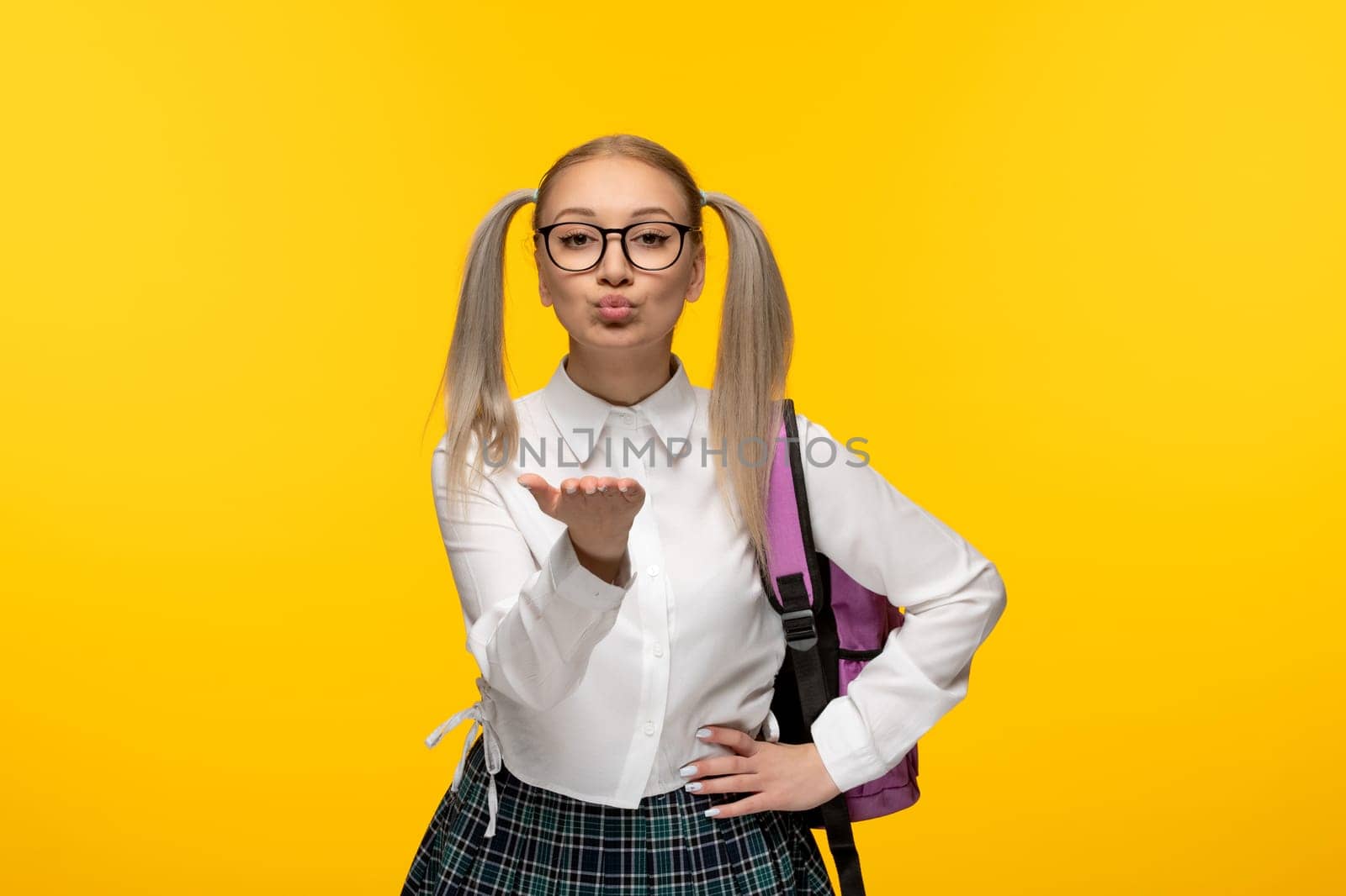 world book day schoolgirl sending cute kiss on yellow background