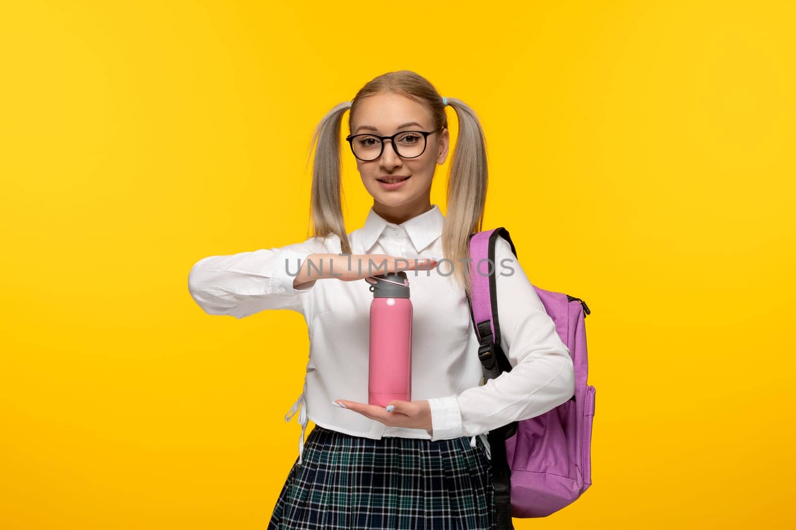 world book day schoolgirl with ponytails holding a pink flask by Kamran