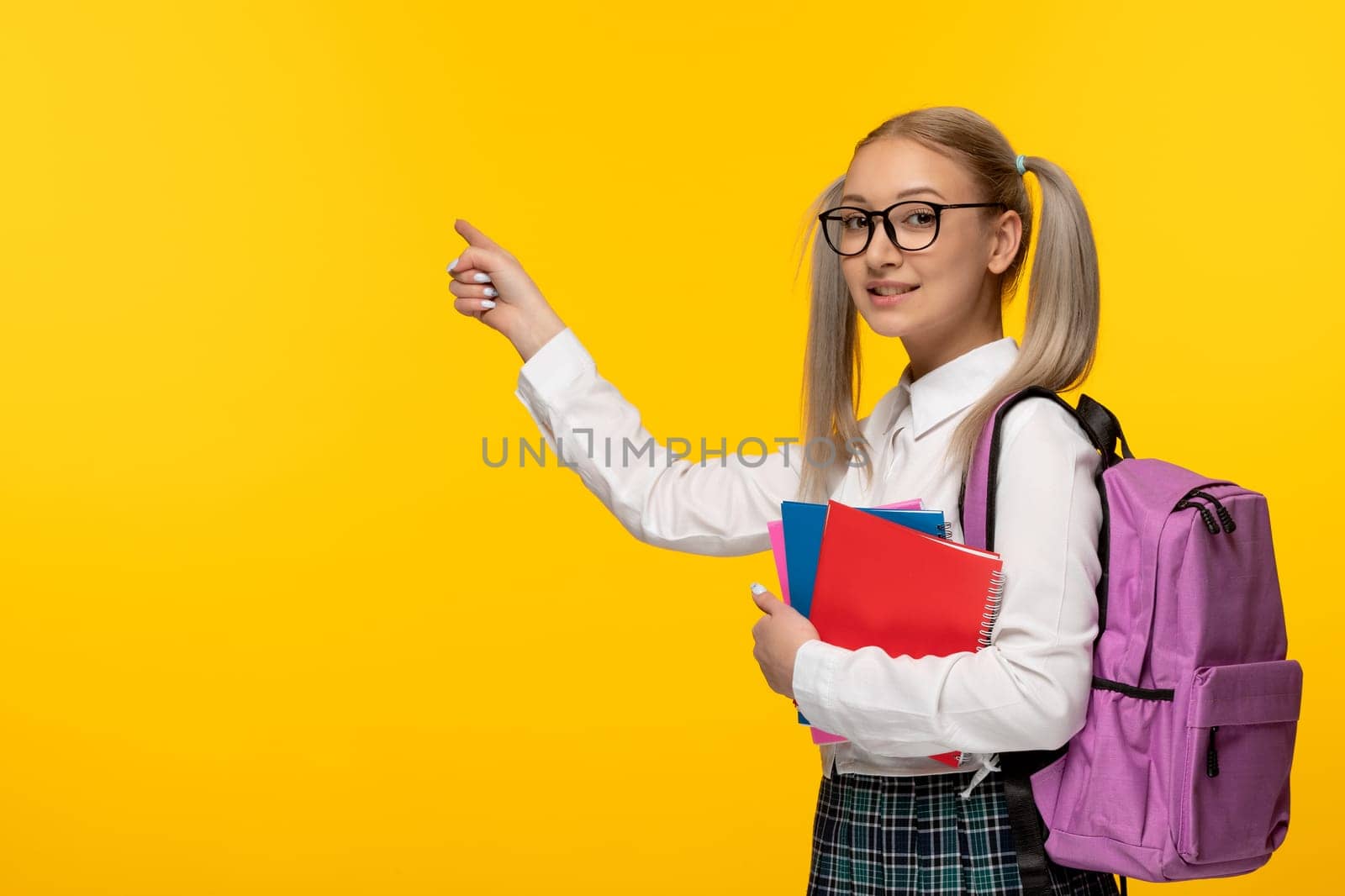 world book day smiling blonde school girl holding colorful notebooks