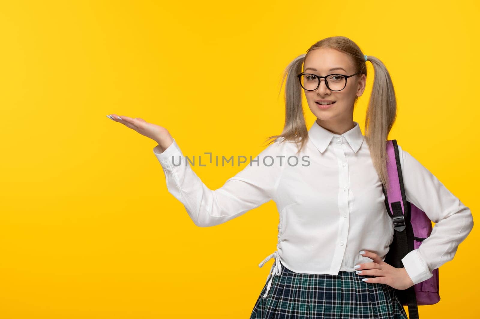 world book day smiling cute school girl with waving hands and pony tails