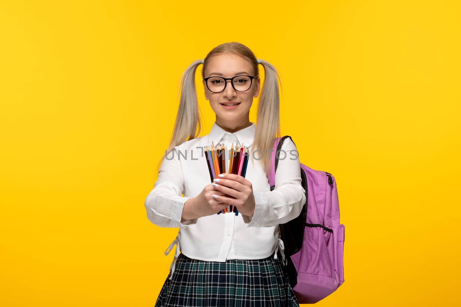 world book day smiling schoolgirl in uniform with pink backpack and colorful pencils