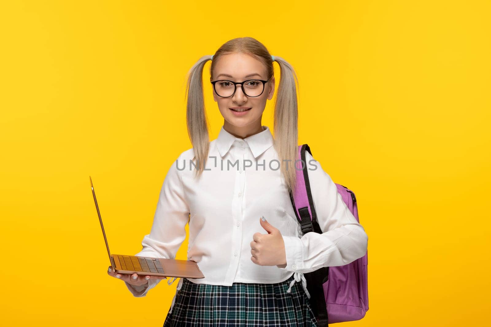 world book day smiling student with ponytails holding a computer