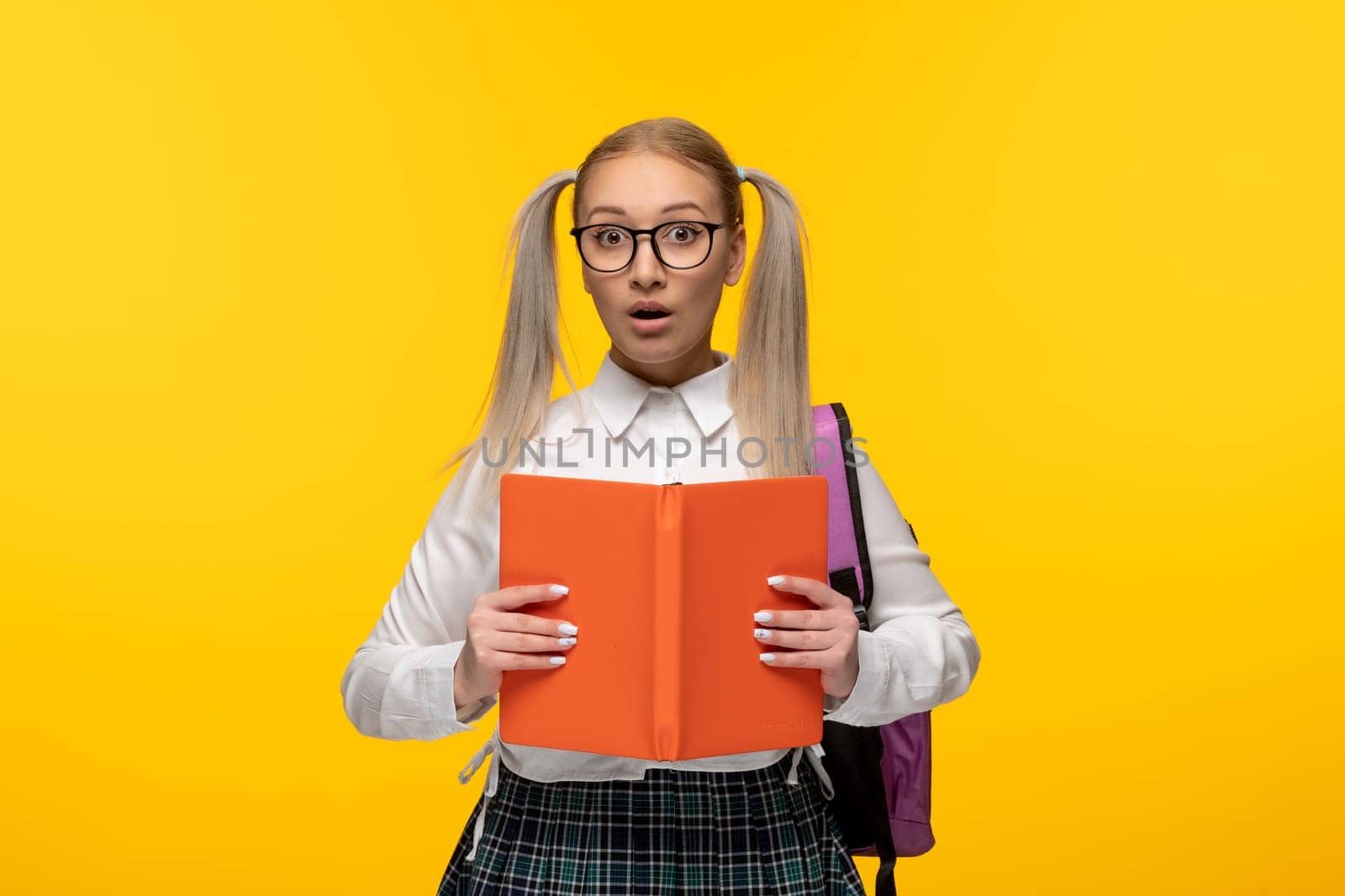 world book day surprised blonde young student holding an open book by Kamran