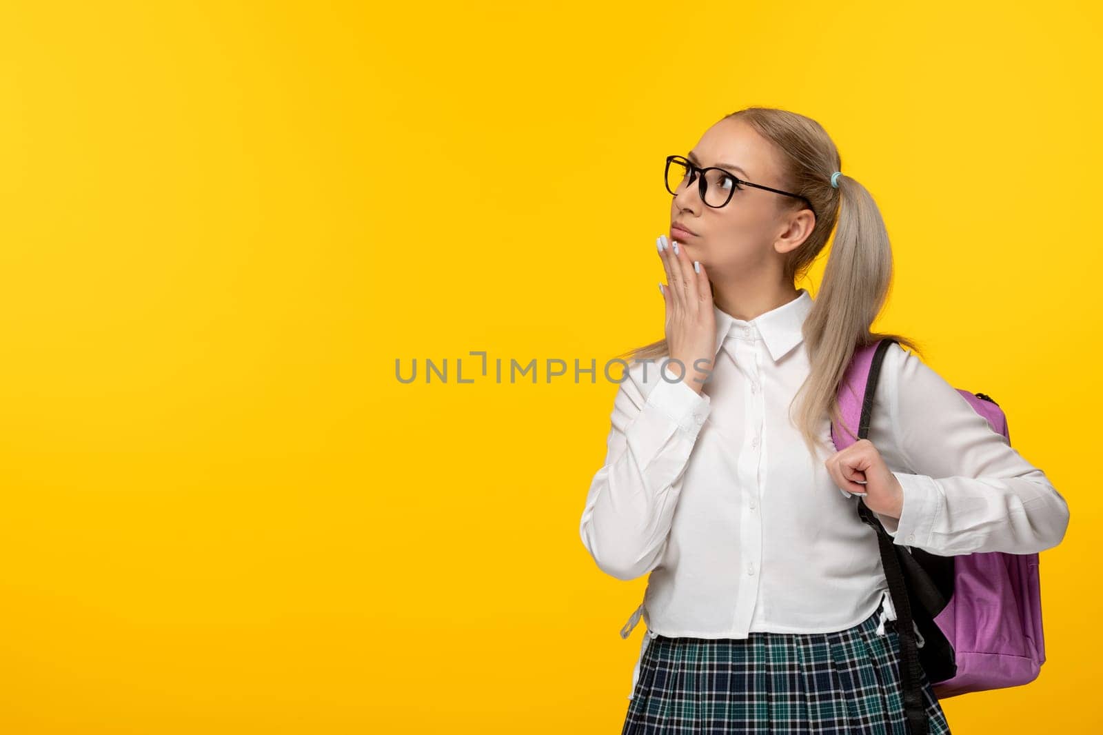 world book day thinking blonde girl with ponytails and pink backback on yellow background