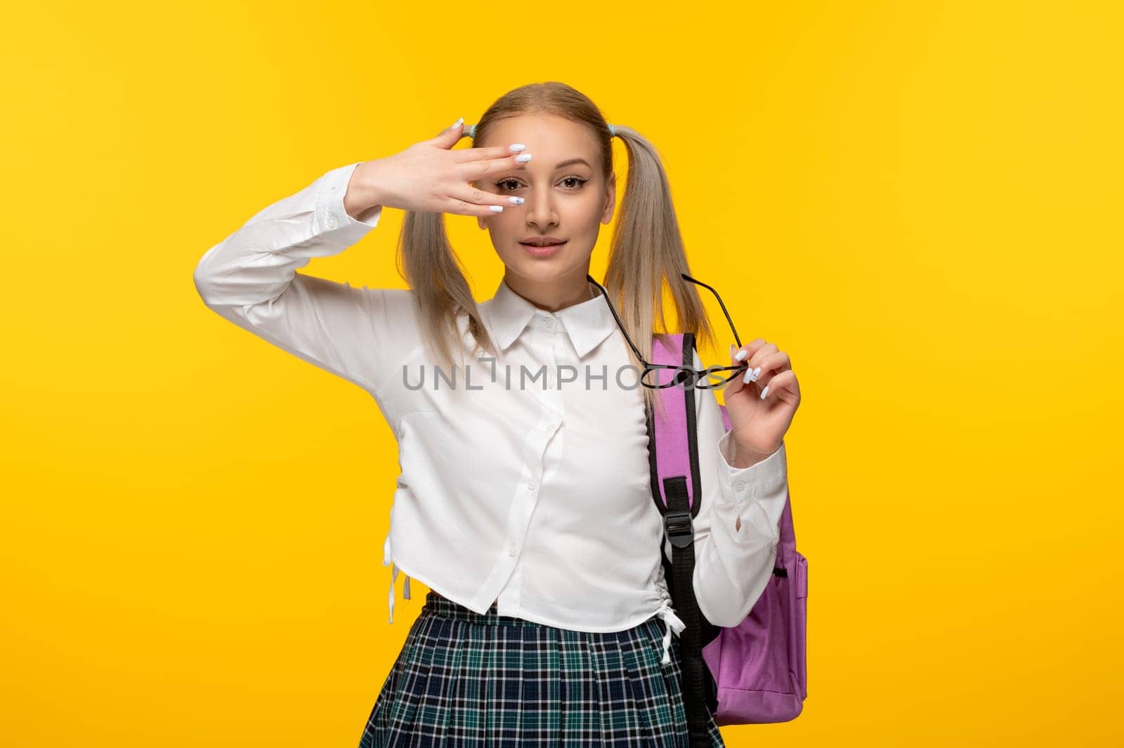 world book day young schoolgirl covering face with the hand on yellow background by Kamran