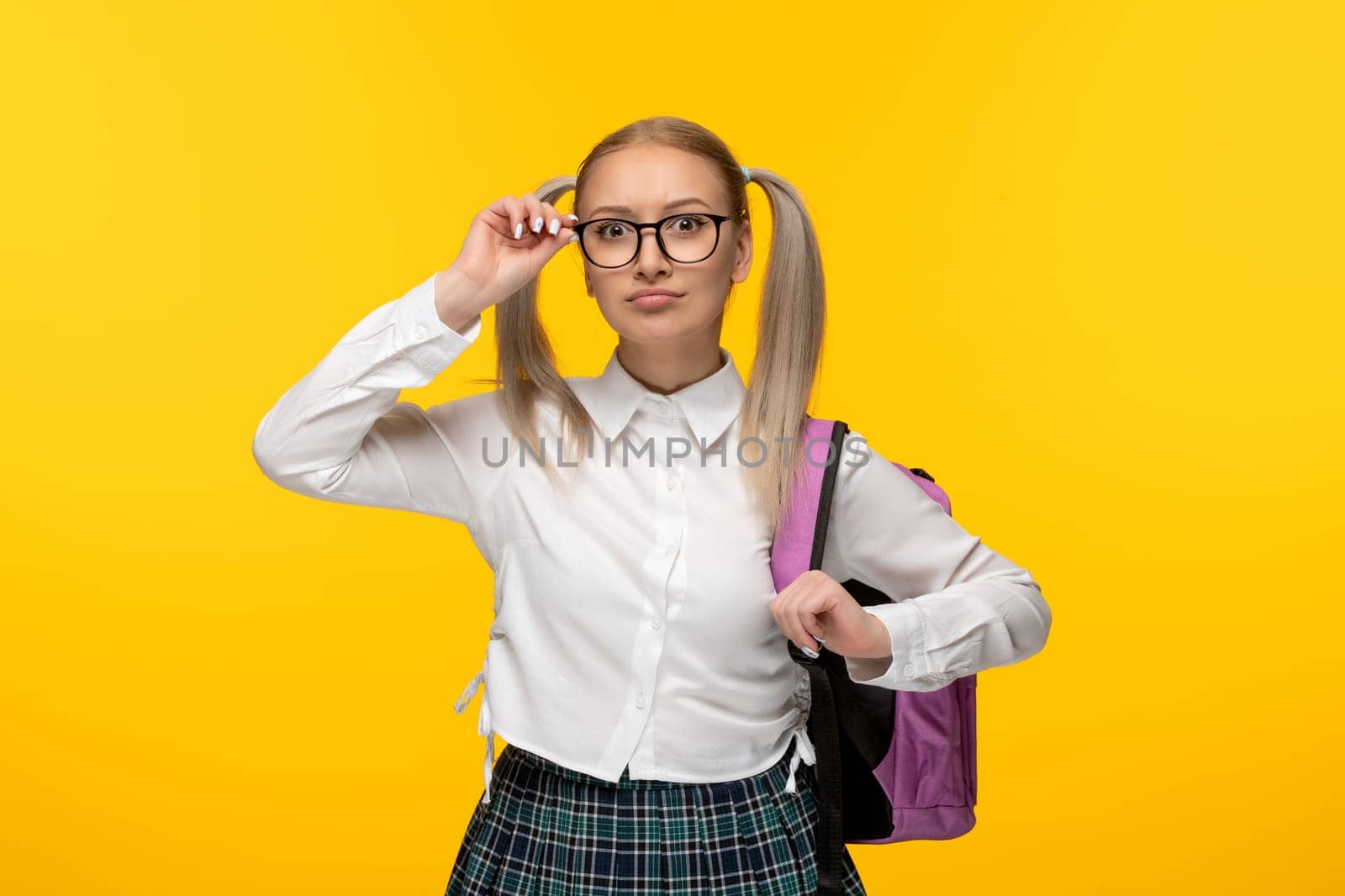 world book day young schoolgirl with glasses wearing uniform with pink backpack
