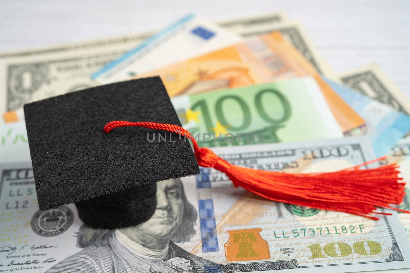 Graduation gap hat on Euro and US dollar banknotes money, Education study fee learning teach concept.