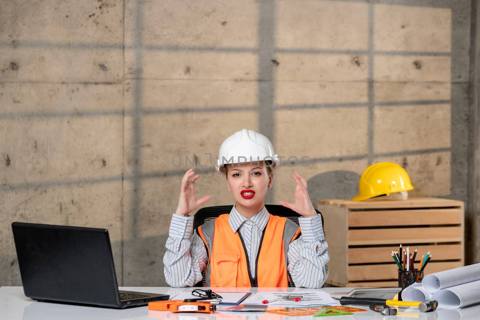 engineer smart young cute blonde girl civil worker in helmet and vest annoyed