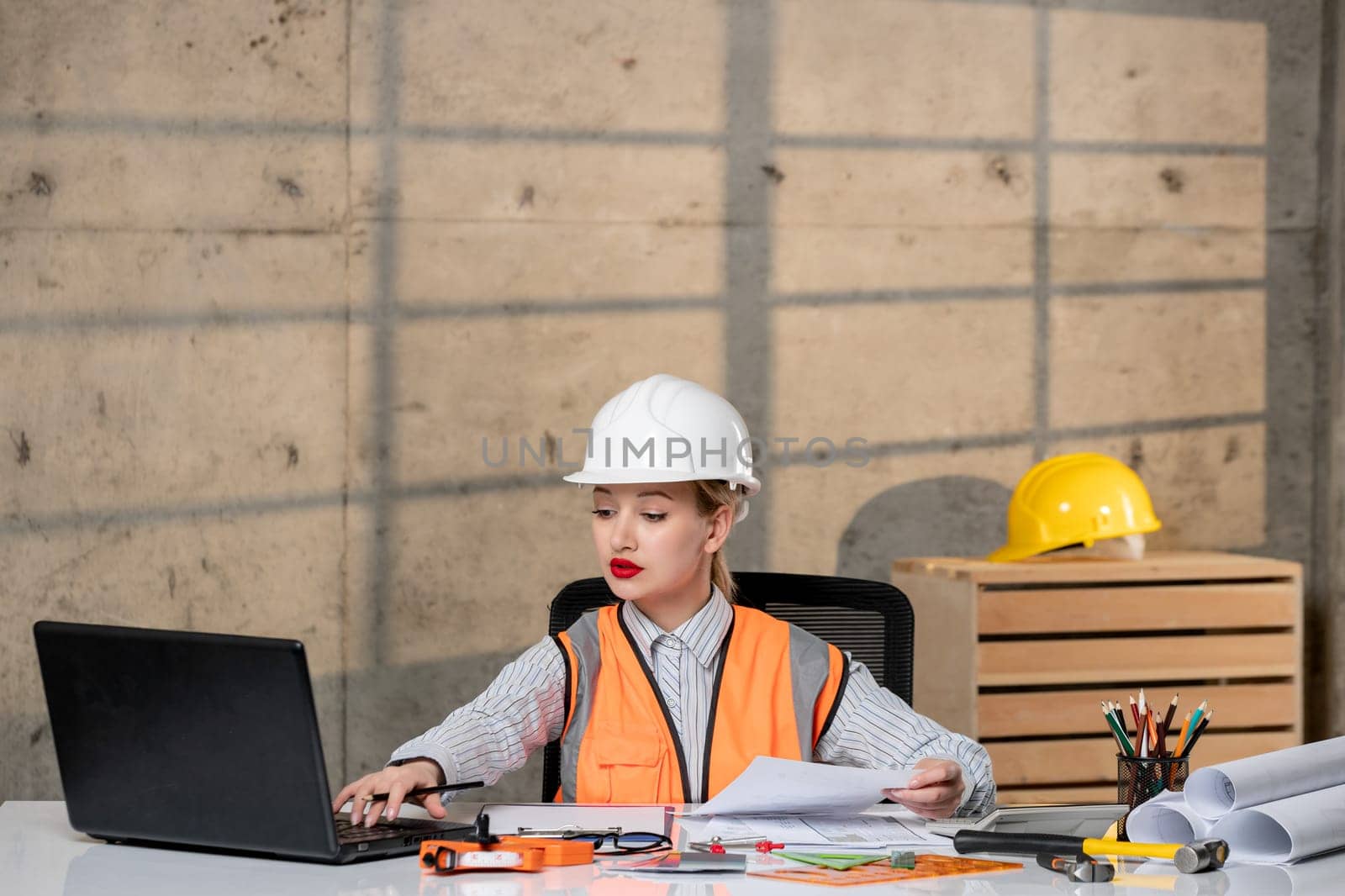 engineer young smart cute blonde girl civil worker in helmet and vest working hard